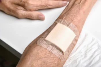 Wound bandage, Dressing arm wound with sterile plaster pad, Accidental wound care treatment in elder old man.